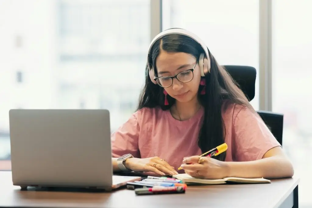 IB Maths student studying online with headphones and laptop